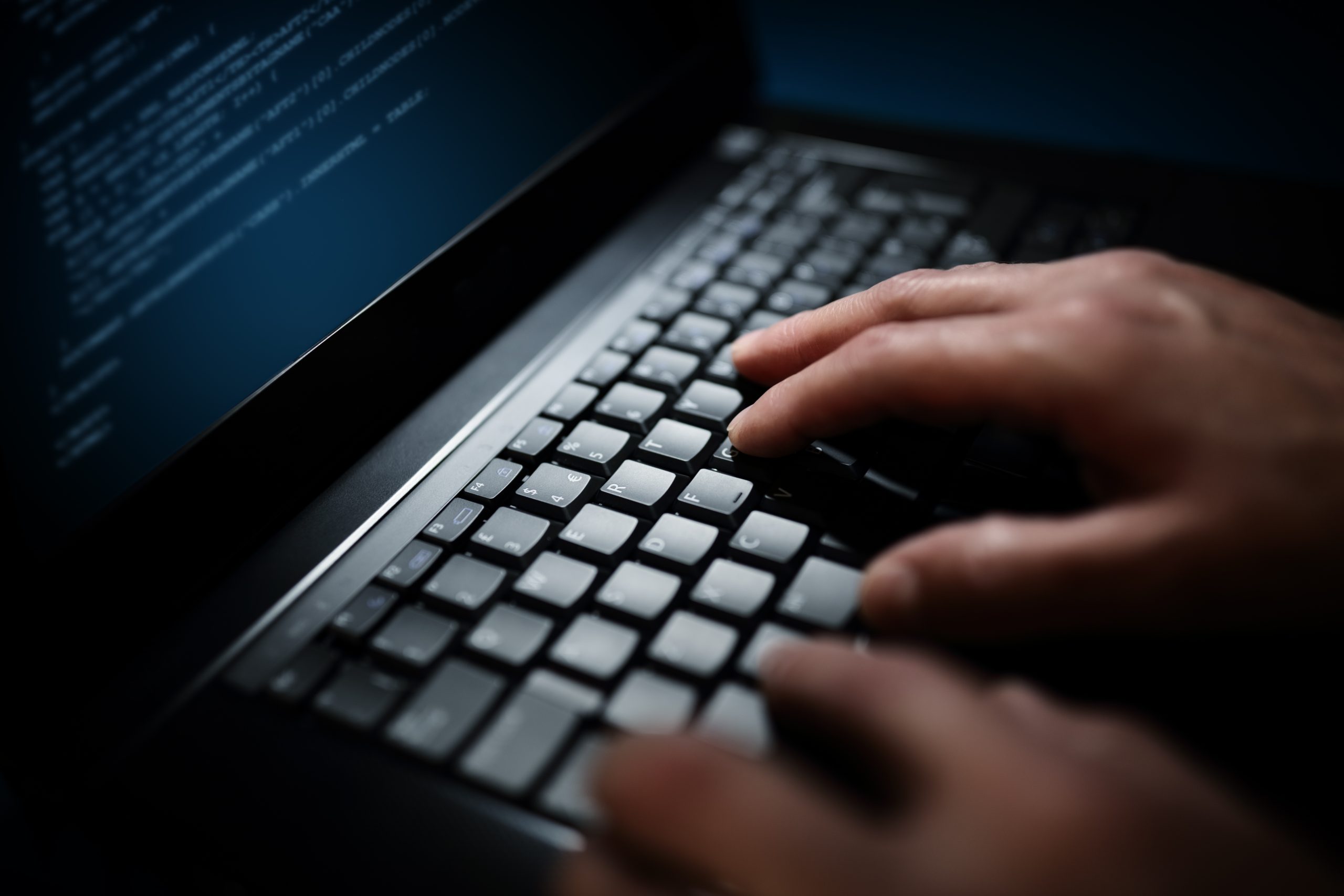 Programmer or computer hacker typing on laptop keyboard ...